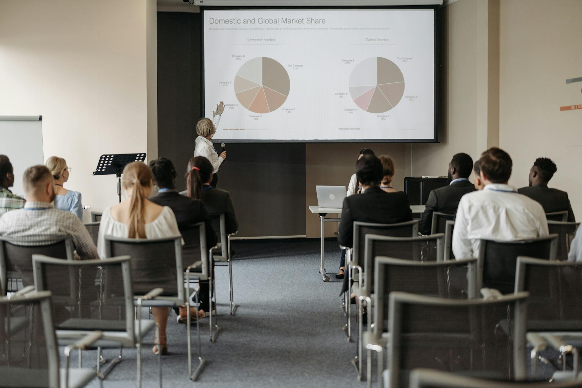people on chairs looking at presentation at business conference